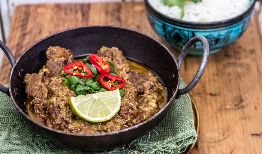A bowl of Rendang served with a rice