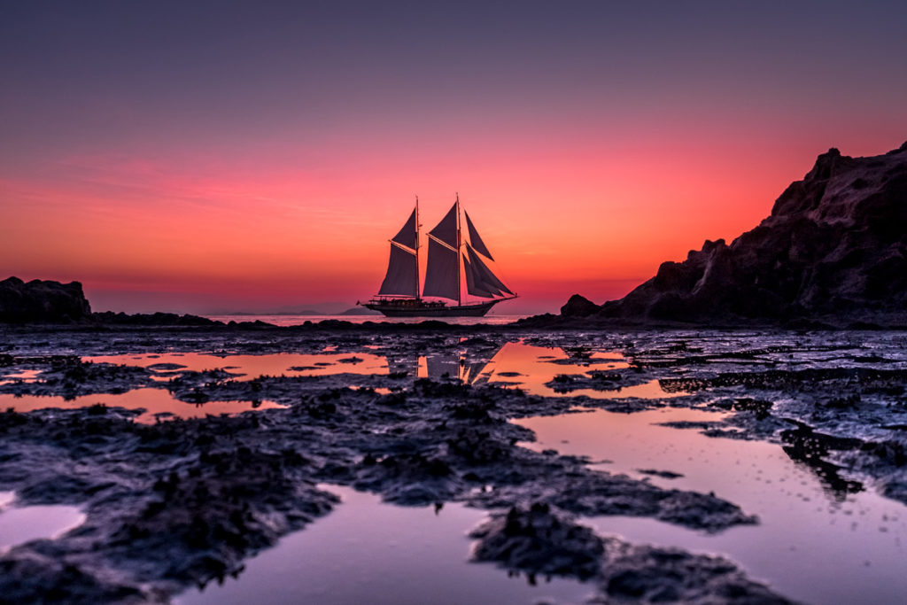 A Phinisi boat is sailing on the evening