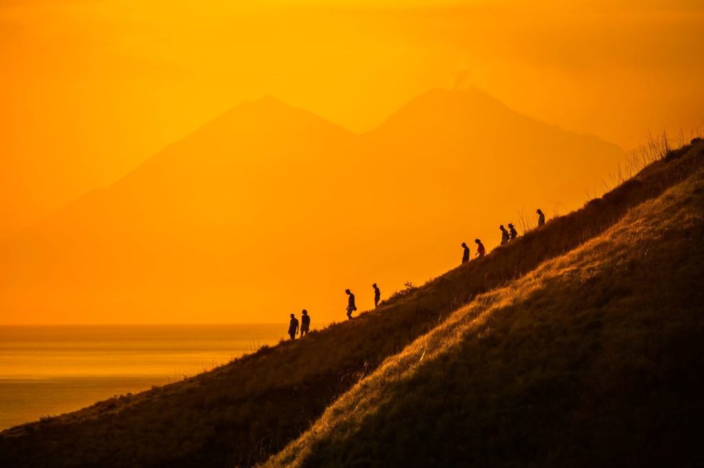 A group of people trekking in the evening